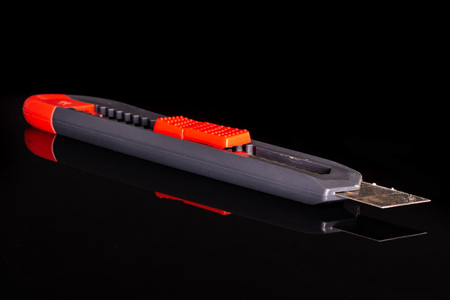 One whole scalpel knife with a sharp blade work item isolated on black glass