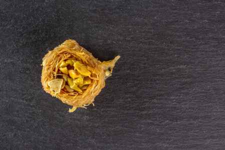 One whole sweet lebanese baklava piece bird nest variety copyspace flatlay on grey stone