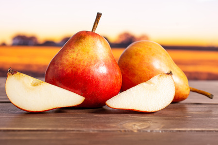 Group of two whole two slices of fresh red pear with autumn fieldの写真素材