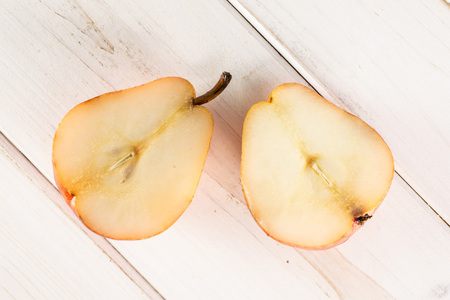 Group of two halves of fresh red pear flatlay on white wood