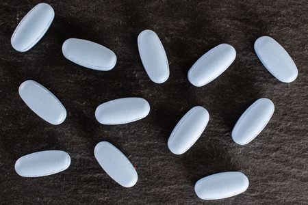 Lot of whole light blue medical drug flatlay on grey stone