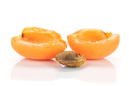 Group of two halves of ripe fresh deep orange apricot with a stone isolated on white backgroundの写真素材
