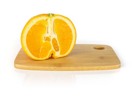 One half of fresh sweet orange on a bamboo cutting board isolated on white backgroundの写真素材