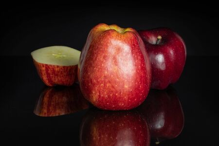 Group of two whole one half of fresh apple red delicious isolated on black glassの写真素材