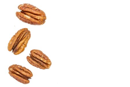 Group of four whole fresh brown pecan nut half copyspace on right flatlay isolated on white backgroundの写真素材