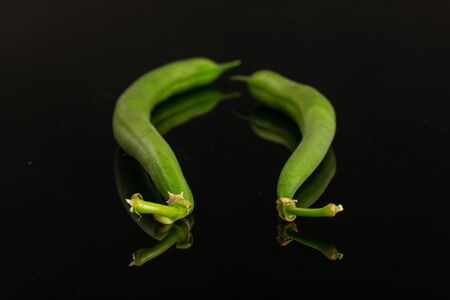 Group of two whole fresh green bean isolated on black glassの写真素材