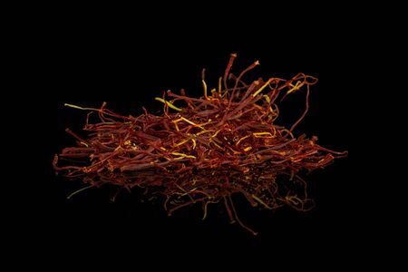 Lot of whole dry shaffron thread isolated on black glassの写真素材
