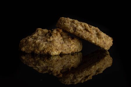 Group of two whole oat crumble biscuit isolated on black glassの写真素材
