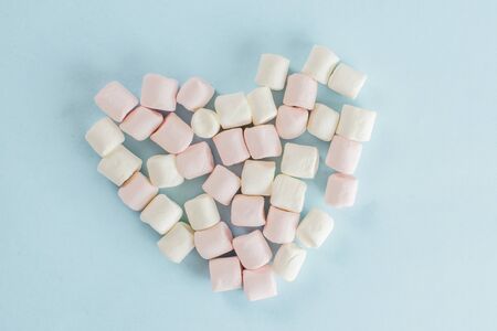 Lot of whole sweet fluffy marshmallow heart symbol flatlay isolated on sky blue background