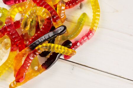 Lot of whole bright colourful jelly worm candy flatlay on white woodの写真素材