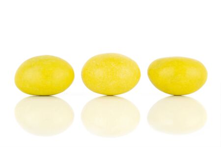 Group of three whole yellow sugared nut dragee in line isolated on white backgroundの写真素材