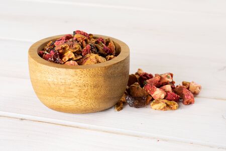 Lot of pieces of lavender strawberry ice tea in wooden bowl on white woodの写真素材