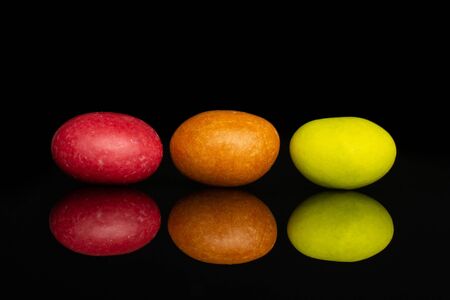 Group of three whole sugared nut dragee isolated on black glassの写真素材