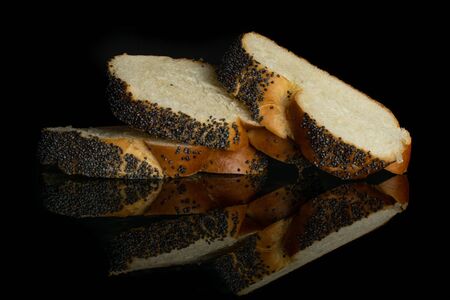 Group of three slices of fresh baked twisted poppy seed bun isolated on black glassの写真素材