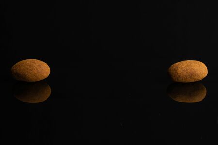 Group of two whole sweet brown chocolate cinnamon almond isolated on black glassの写真素材