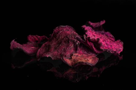 Lot of slices of dried red beetroot isolated on black glassの写真素材