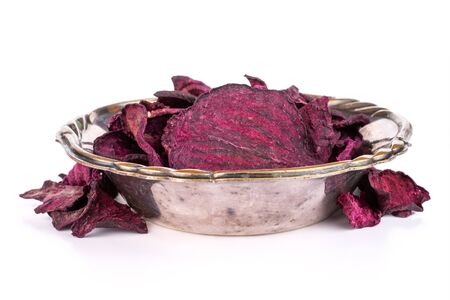 Lot of slices of dried red beetroot in metal bowl isolated on white backgroundの写真素材