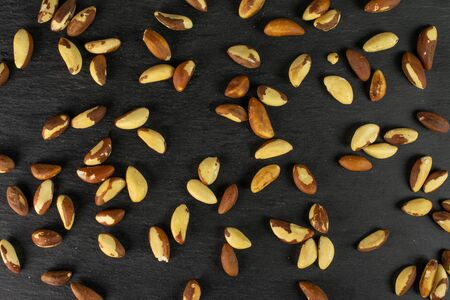 Lot of whole raw brown brazil nut flatlay on grey stoneの写真素材