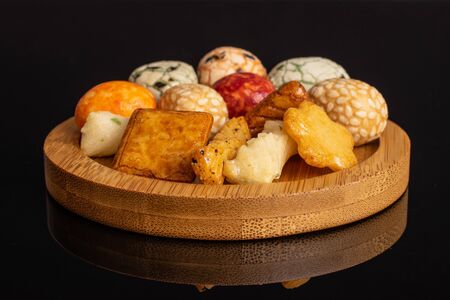 Lot of whole rice japan assortment on round bamboo coaster isolated on black glassの写真素材