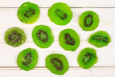 Group of ten slices of sweet green candied kiwifruit flatlay on white woodの写真素材