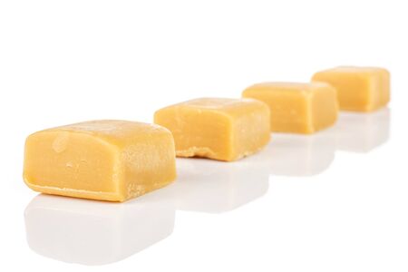Group of four whole sweet golden caramel candy isolated on white backgroundの写真素材