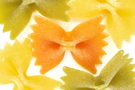 Group of five whole red, yellow and green uncooked farfalle flatlay isolated on white backgroundの写真素材