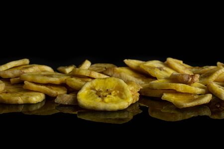 Lot of slices of sweet yellow dry banana isolated on black glassの写真素材
