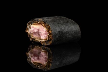 One half of sweet black liquorice candy isolated on black glassの写真素材