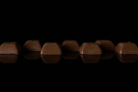 Lot of whole fresh chocolate piece isolated on black glass