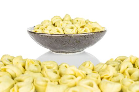 Lot of whole fresh yellow spinach filled tortelloni large group is in the front and the rest is isolated on white backgroundの写真素材