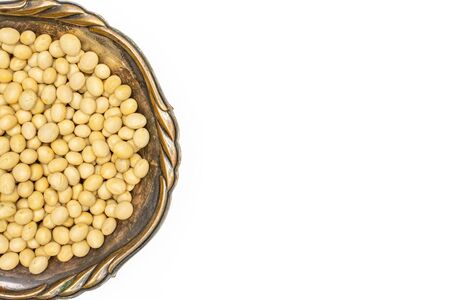 Lot of whole raw yellow soya bean copyspace right in old iron bowl flatlay isolated on white backgroundの写真素材
