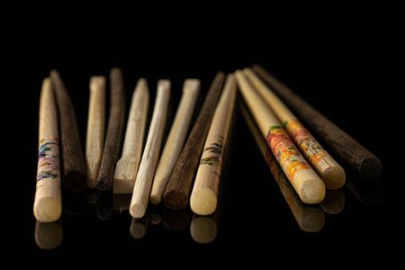 Lot of whole asian brown chopsticks isolated on black glassの写真素材