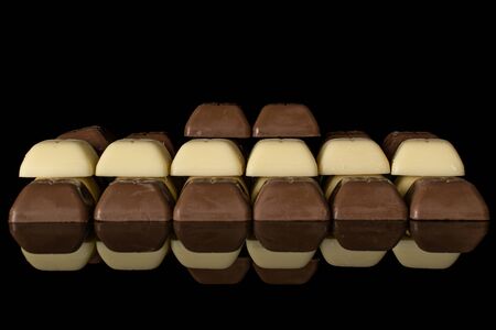 Lot of whole arranged fresh chocolate piece isolated on black glassの写真素材