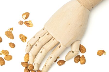 Lot of whole brown almond nut with wooden arm flatlay on white background