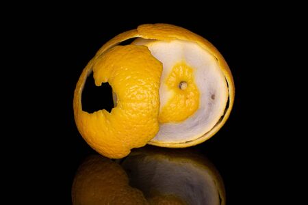 One whole fresh bright orange isolated on black glassの写真素材