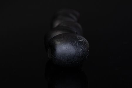 Lot of whole tasty black olive isolated on black glassの写真素材