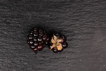 Group of two whole fresh black blackberry flatlay on grey stoneの写真素材