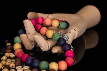 Lot of whole wooden bead with wooden hand isolated on black glassの写真素材