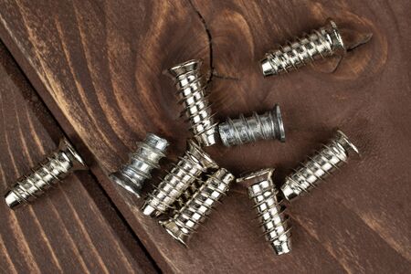 Group of nine whole metallic glossy bolt flatlay on brown woodの写真素材