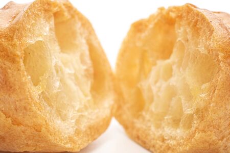 Group of two halves of baked golden profiterole one sliced macro isolated on white backgroundの写真素材