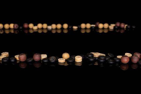 Lot of whole wooden bead in row isolated on black glassの写真素材