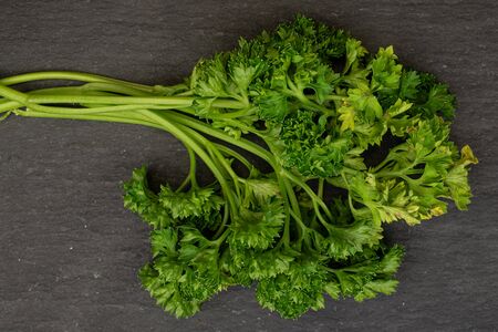 Lot of whole fresh green parsley flatlay on grey stoneの写真素材