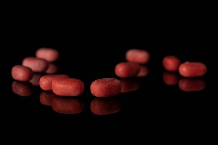 Lot of whole sweet pastel candy heap isolated on black glassの写真素材