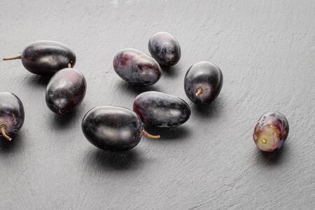 Lot of whole fresh black grape on grey stoneの写真素材