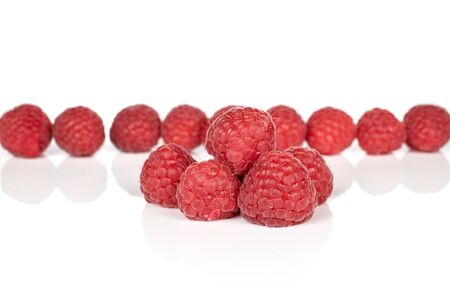 Lot of whole fresh red raspberry isolated on white background