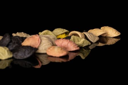 Lot of whole colorful pasta orecchiette heap isolated on black glassの写真素材