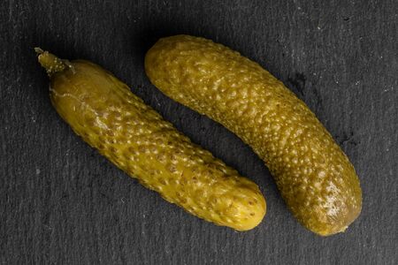 Group of two whole sour green pickle flatlay on grey stoneの写真素材