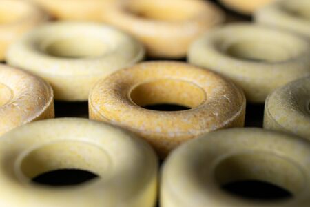 Lot of whole bright round pale yellow candy isolated on black glassの写真素材