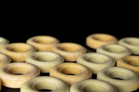 Lot of whole arranged round pale yellow candy isolated on black glass