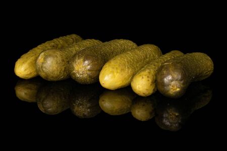 Group of six whole sour green pickle isolated on black glassの写真素材